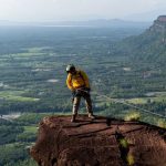 rescue-hiker-with-backpack-climbs-natural-rocky-wall-wearing-climbing-equipment-rope-carabiner_130181-937
